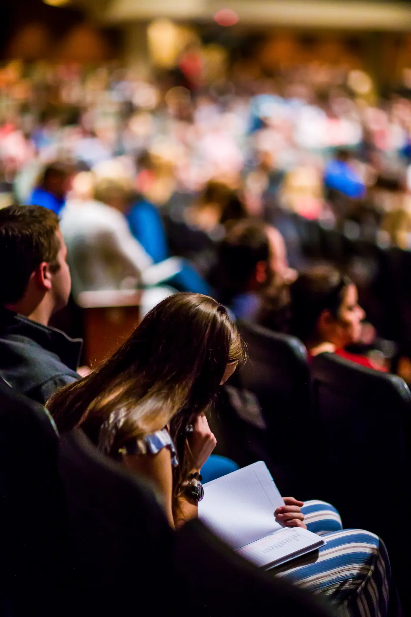 Pubblico seduto in una grande sala durante una fiera
